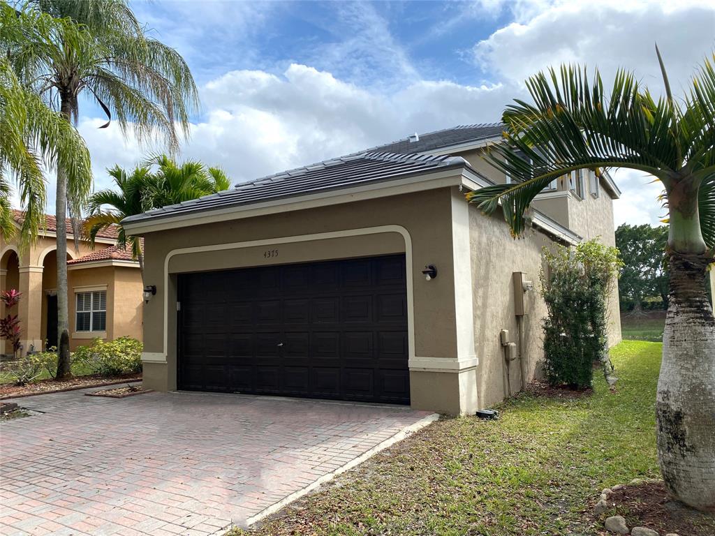 4375 Foxtail Lane Weston, FL 33331 - Photo 53 of 84 a front view of a house with a yard and garage
