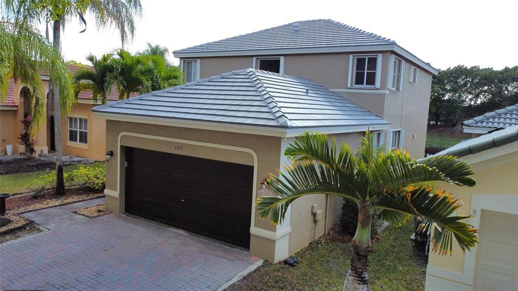 4375 Foxtail Lane Weston, FL 33331 - Photo 56 of 84 a front view of a house with a garden