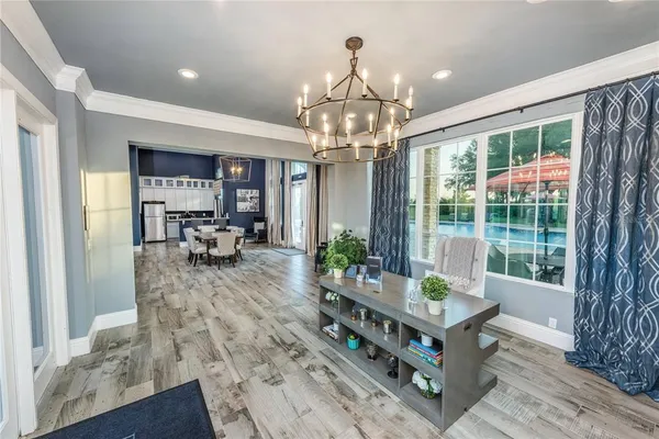 a living room with furniture a chandelier and a dining table