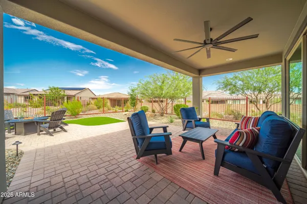 a living room with patio furniture and a floor to ceiling window
