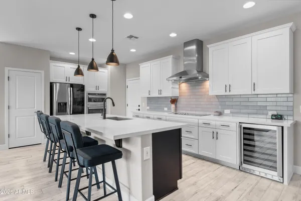 a kitchen with a dining table chairs stainless steel appliances and cabinets
