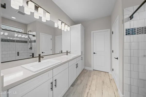 a spacious bathroom with a double vanity sink and mirror