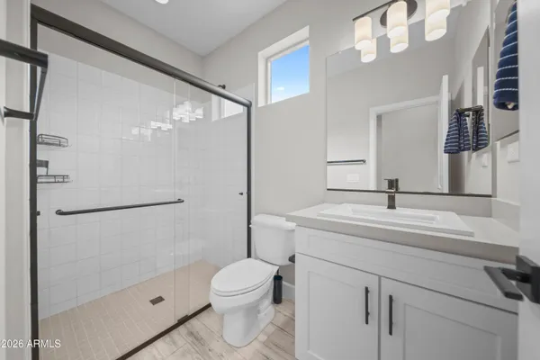 a bathroom with a sink a toilet and shower