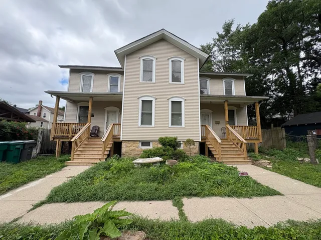 a front view of a house with garden and trees