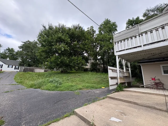 a view of a house with a yard and street