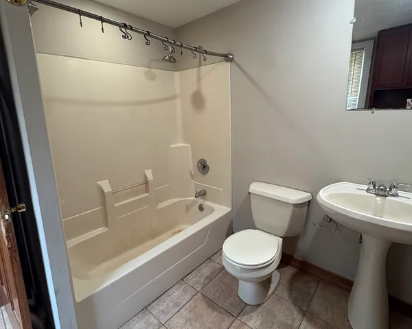 a white toilet sitting next to a bathroom sink and tub