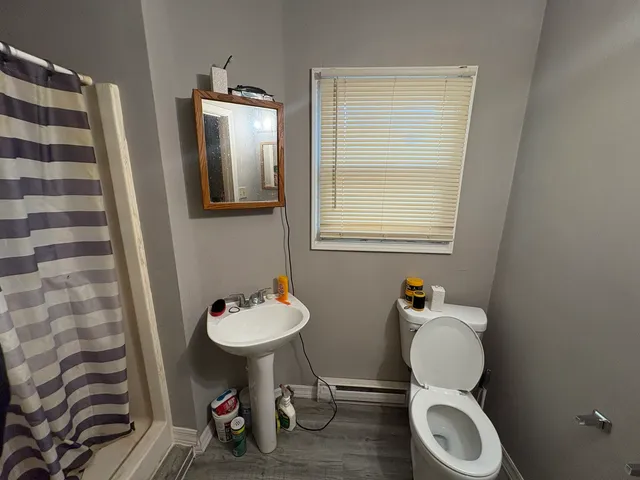 a bathroom with a toilet a sink and mirror