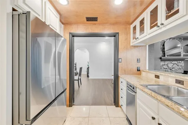 a kitchen with stainless steel appliances granite countertop a refrigerator and a sink