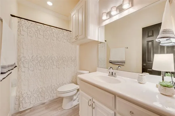 a bathroom with a granite countertop sink a toilet and a mirror