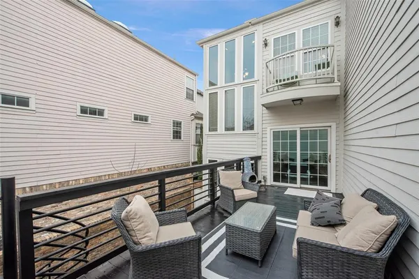 a view of a patio with couches chairs and wooden floor