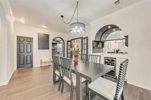 a view of a dining room with furniture a chandelier and wooden floor