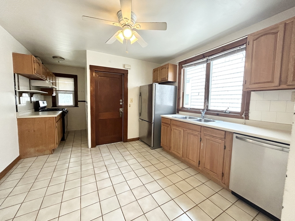 a kitchen with stainless steel appliances kitchen island granite countertop a refrigerator and a sink