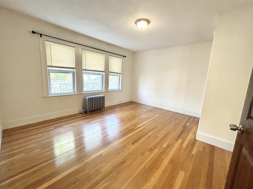 11 Romsey Street, Unit 3 Boston, MA 02125 - Photo 4 of 7 a view of empty room with wooden floor and fan