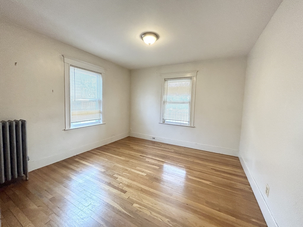 11 Romsey Street, Unit 3 Boston, MA 02125 - Photo 6 of 7 an empty room with wooden floor and windows