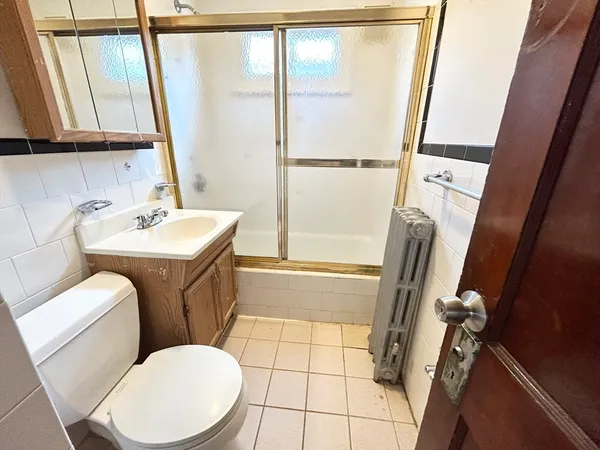 a bathroom with a sink a toilet a mirror and a tub