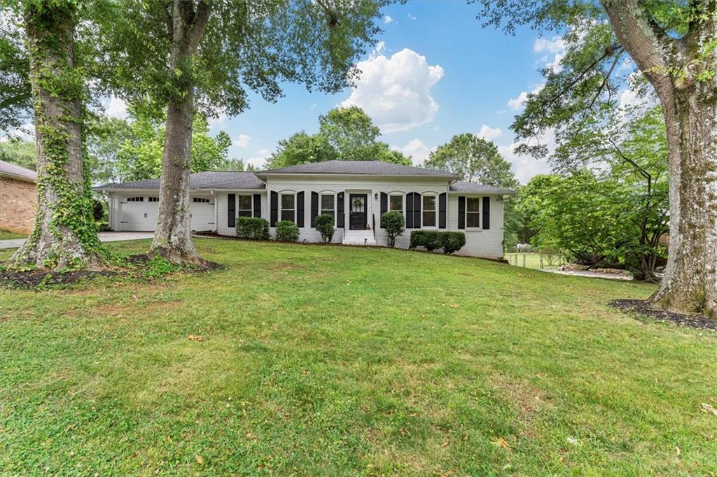 a view of a house with a yard and sitting area