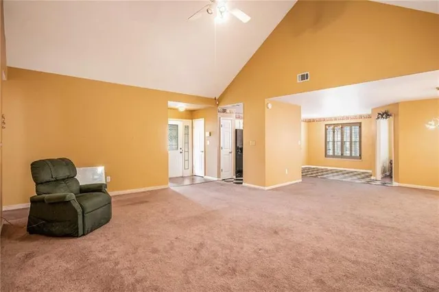 a view of an empty room with furniture and a window