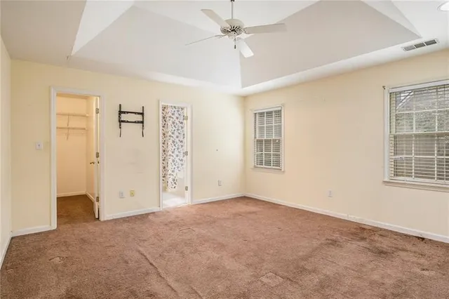 an empty room with windows and fan