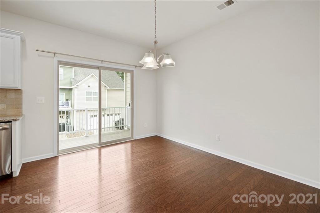 206 Butterfly Place, Unit 185 Tega Cay, SC 29708 - Photo 11 of 36 a view of an empty room with wooden floor and a window