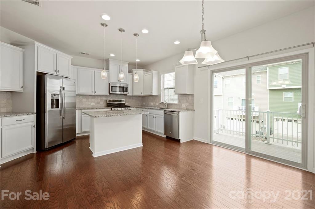206 Butterfly Place, Unit 185 Tega Cay, SC 29708 - Photo 12 of 36 a kitchen with stainless steel appliances granite countertop a refrigerator a sink dishwasher a stove and white cabinets with wooden floor