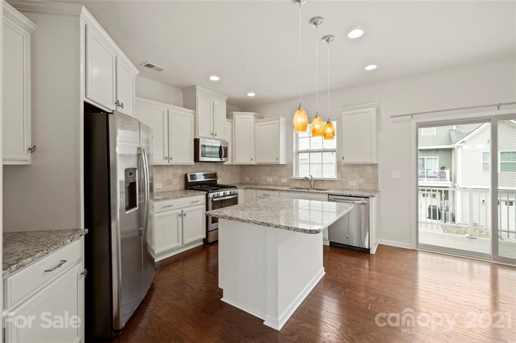 206 Butterfly Place, Unit 185 Tega Cay, SC 29708 - Photo 15 of 36 a kitchen with white cabinets and appliances