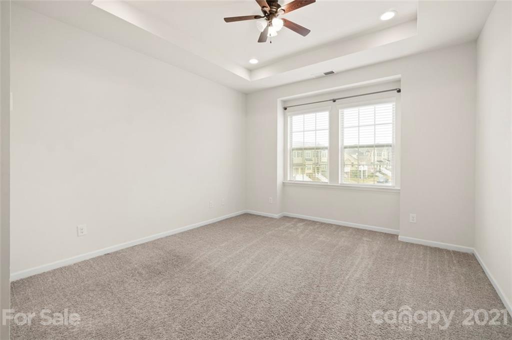 206 Butterfly Place, Unit 185 Tega Cay, SC 29708 - Photo 22 of 36 an empty room with a window and a fan