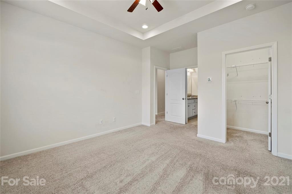 206 Butterfly Place, Unit 185 Tega Cay, SC 29708 - Photo 24 of 36 an empty room with chandelier and stainless steel appliances