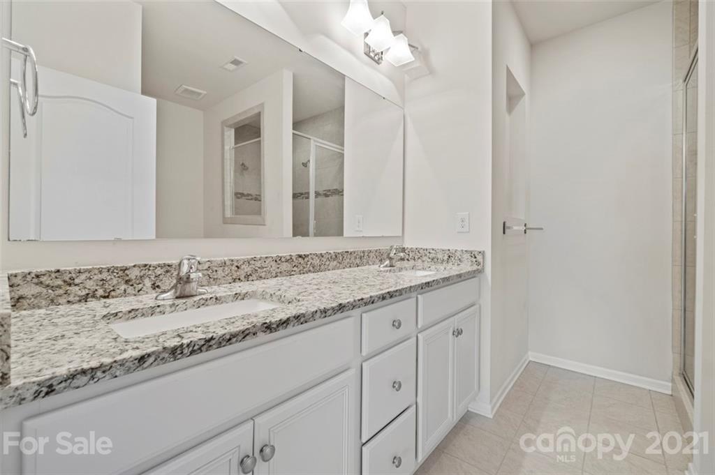 206 Butterfly Place, Unit 185 Tega Cay, SC 29708 - Photo 25 of 36 a bathroom with a granite countertop sink and a mirror