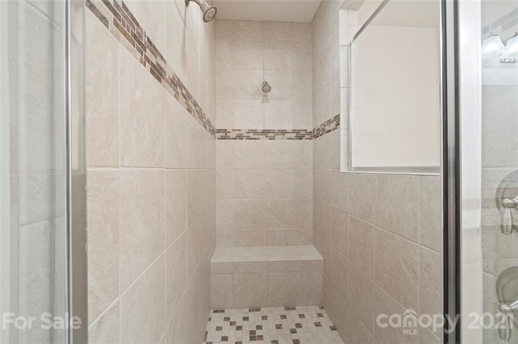 206 Butterfly Place, Unit 185 Tega Cay, SC 29708 - Photo 27 of 36 a bathroom with a glass shower door