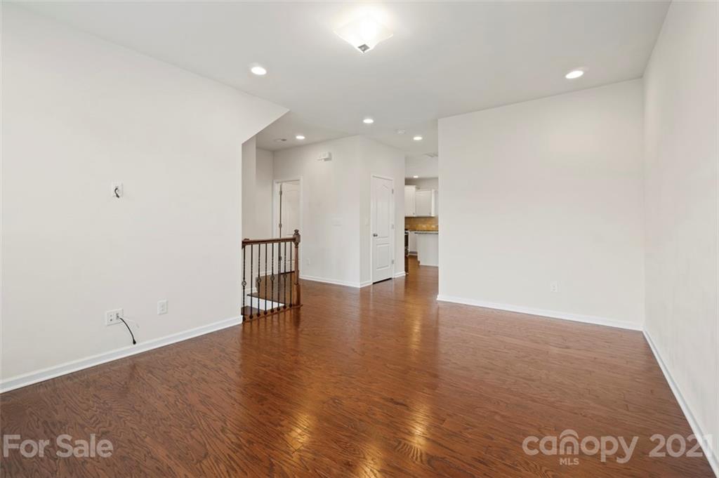 206 Butterfly Place, Unit 185 Tega Cay, SC 29708 - Photo 9 of 36 an empty room with wooden floor and windows