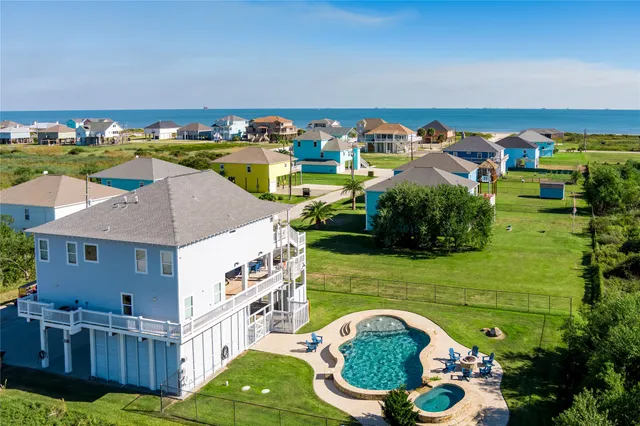 an aerial view of a house with outdoor space and swimming pool