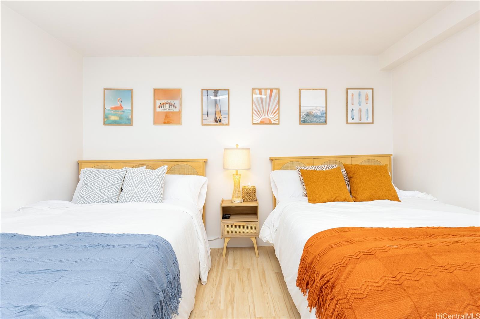 a bed room with two beds and painting on the wall