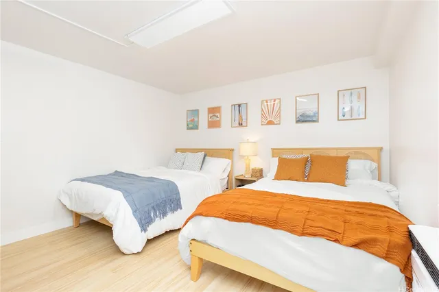 a bedroom with two beds and painting on the wall