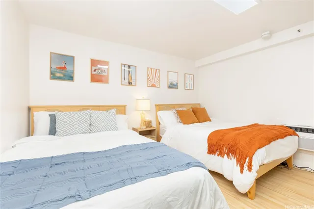 a bedroom with two beds and painting on the wall