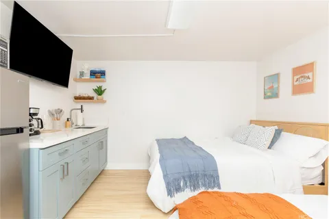 a spacious bedroom with a bed and a flat screen tv