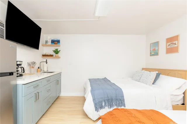 a spacious bedroom with a bed and a flat screen tv