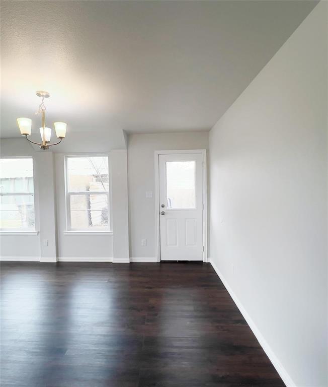 602 Sabine Avenue Cleburne, TX 76031 - Photo 9 of 14 an empty room with wooden floor and windows