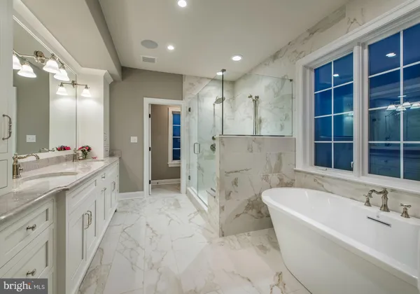 a spacious bathroom with a granite countertop tub sink shower and a mirror