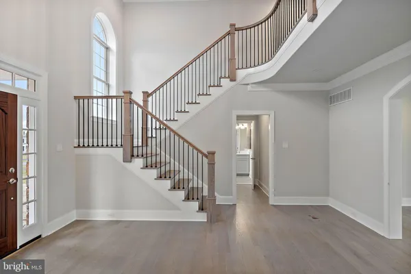 a view of staircase with railing and white walls