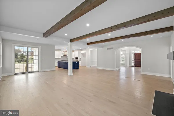 a view of a big room with wooden floor and windows