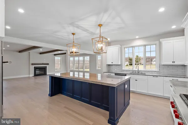 a large kitchen with granite countertop a sink and white cabinets