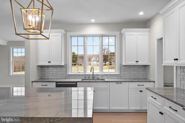 a kitchen with stainless steel appliances granite countertop a sink a window and cabinets