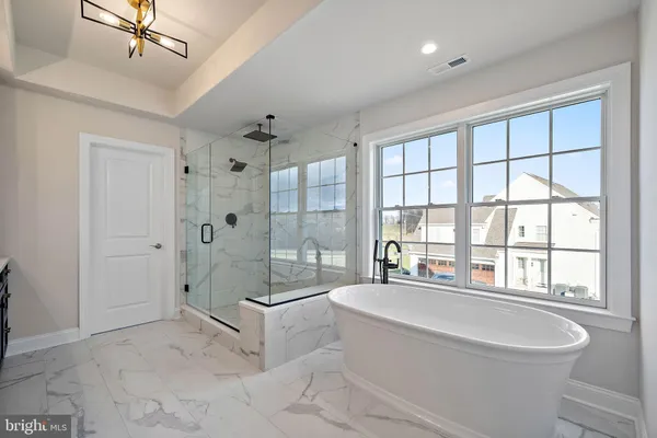a spacious bathroom with a tub shower sink and mirror