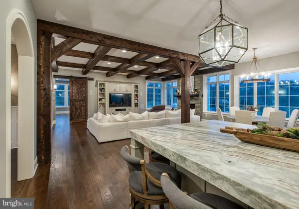 a dining hall with stainless steel appliances granite countertop a stove and cabinets with wooden floor