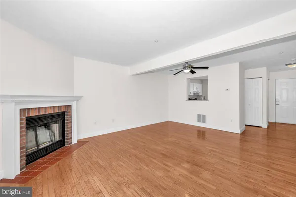 a view of empty room with wooden floor and fireplace