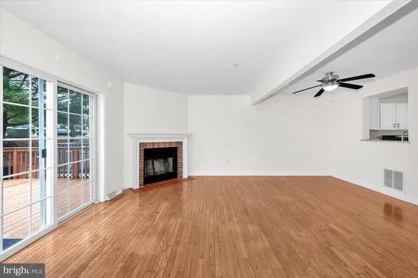 a view of empty room with wooden floor and fireplace