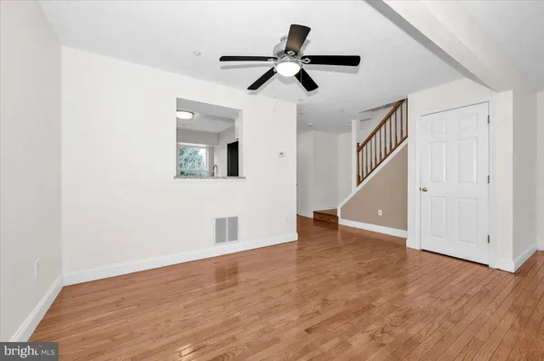wooden floor chandelier fan and windows in a room