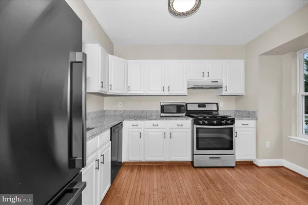 a kitchen with a white stove top oven and white cabinets