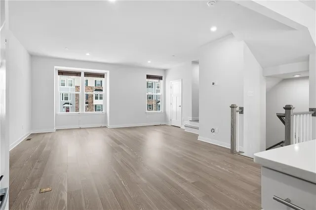 a view of a livingroom with wooden floor and staircase