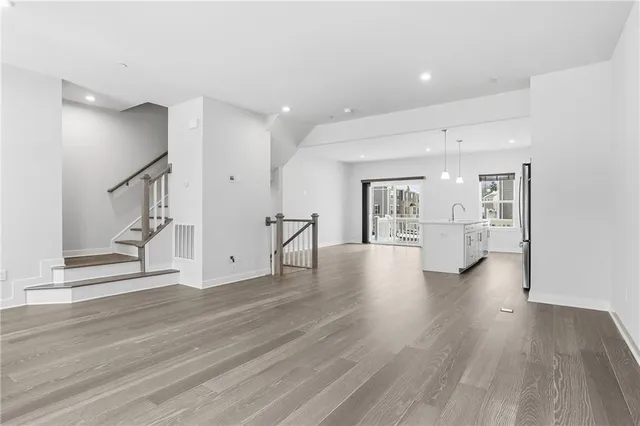 a view of a big room with wooden floor and windows